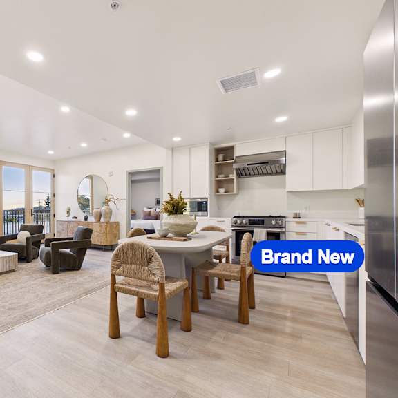 a modern kitchen with a dining area and a living room.