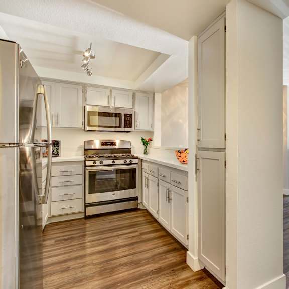 a modern kitchen with white cabinets and stainless steel appliances.