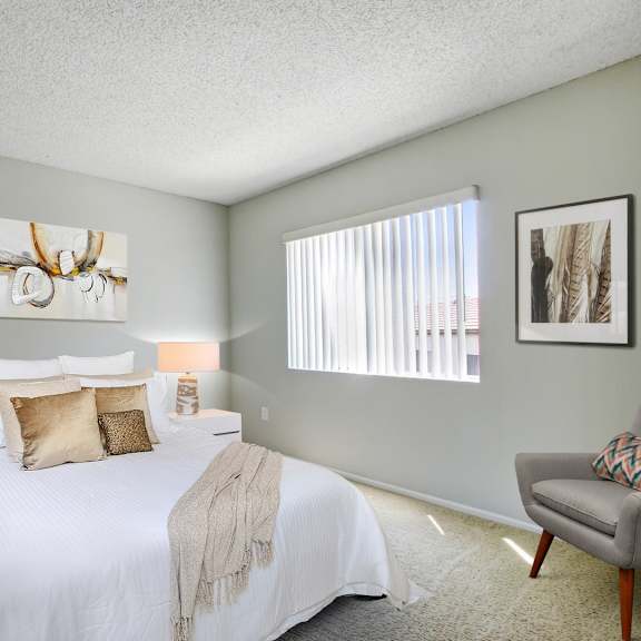 a bedroom with a large bed and a chair.