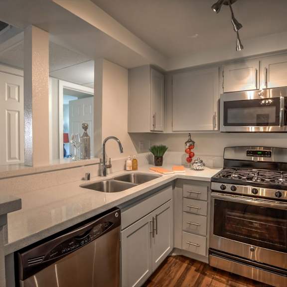 a modern kitchen with stainless steel appliances and white cabinets.