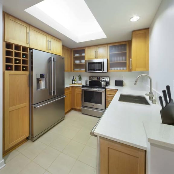 Thumbnail 1 of 9 a kitchen with stainless steel appliances and a white counter top