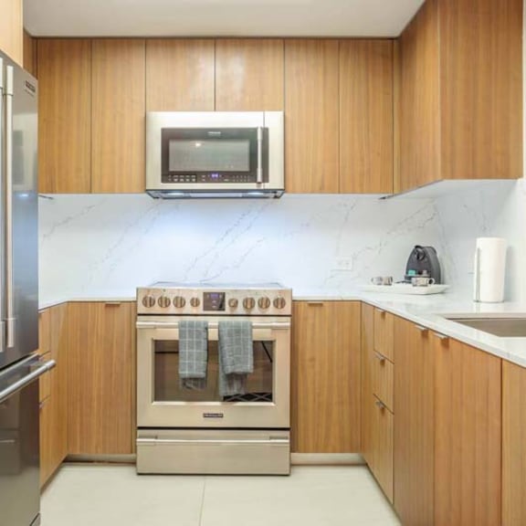 Thumbnail 2 of 7 a kitchen with stainless steel appliances and wooden cabinets
