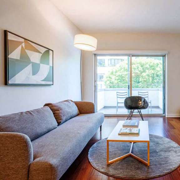 Thumbnail 2 of 6 a living room with a couch and a table and a television at Wilshire Margot, Los Angeles