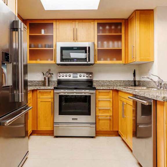 Thumbnail 3 of 6 a kitchen with stainless steel appliances and wooden cabinets at Wilshire Margot, Los Angeles California