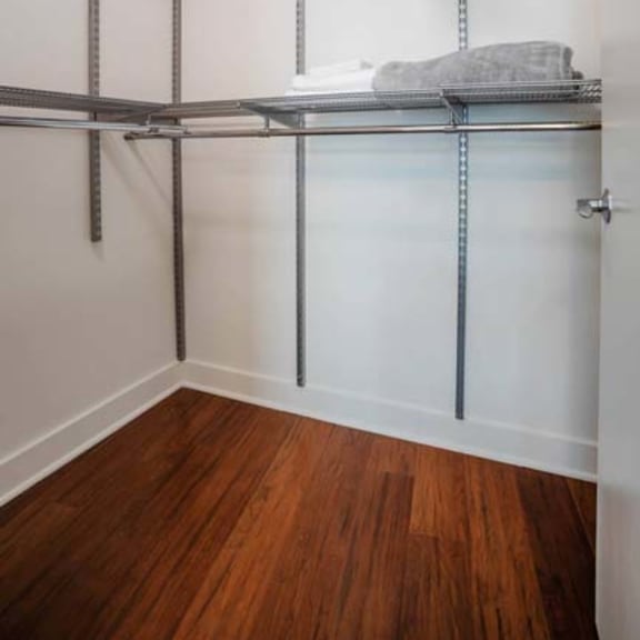 Thumbnail 5 of 7 a large closet with metal shelving and a wooden floor