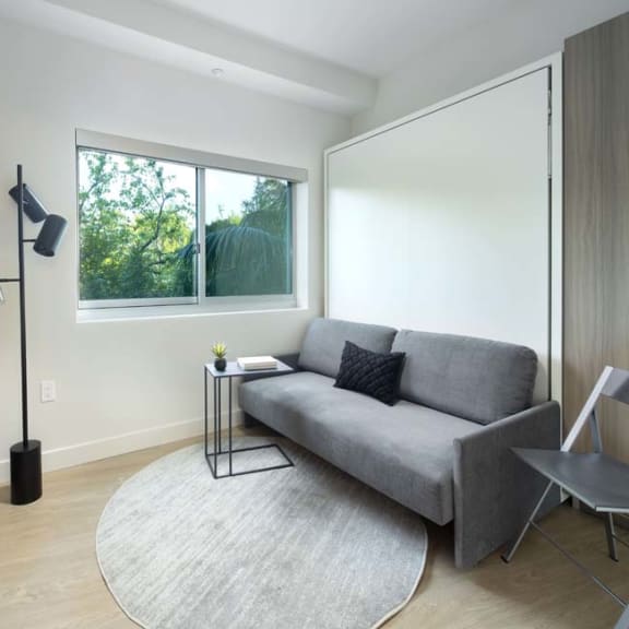 Thumbnail 6 of 9 a living room with a couch and a window