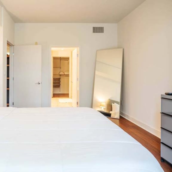 Thumbnail 6 of 7 a large white bed in a room with a mirror