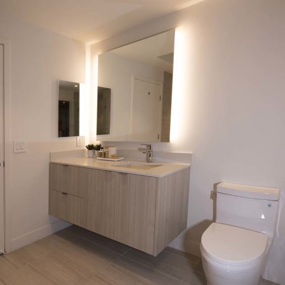 Thumbnail 7 of 8 a bathroom with a toilet and a sink and a mirror