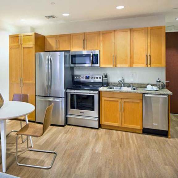 Thumbnail 1 of 4 a kitchen with stainless steel appliances and a table at Wilshire Margot, California