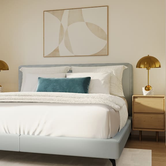a bed with a white comforter and a blue pillow is flanked by two lamps on either side.