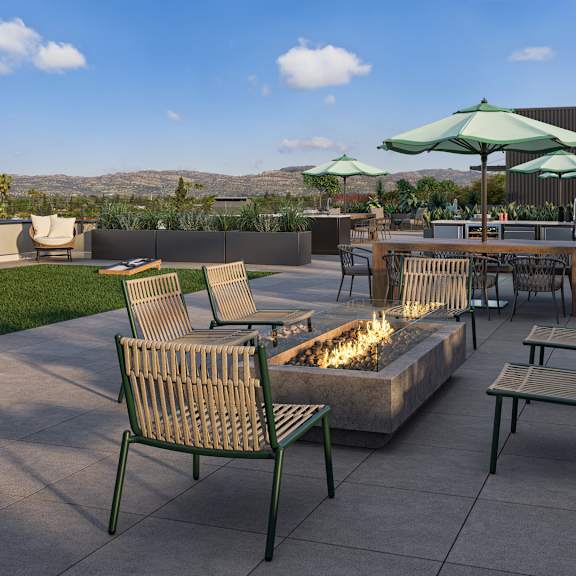 a patio with a fire pit and chairs.