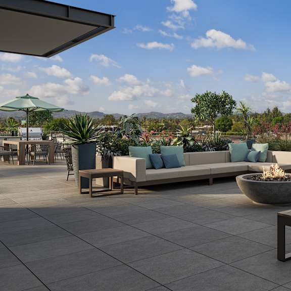 a patio with a couch, table, and plants.