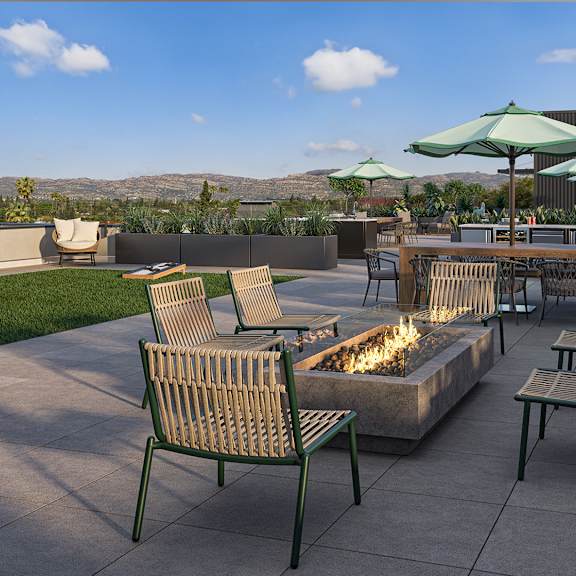 a patio with a fire pit and chairs.
