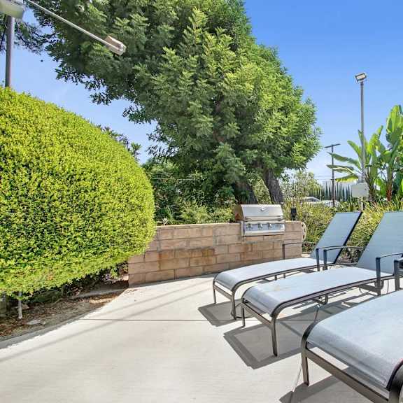 a set of four metal lounge chairs are placed on a patio.