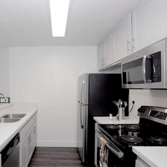a kitchen with black appliances and white countertops.
