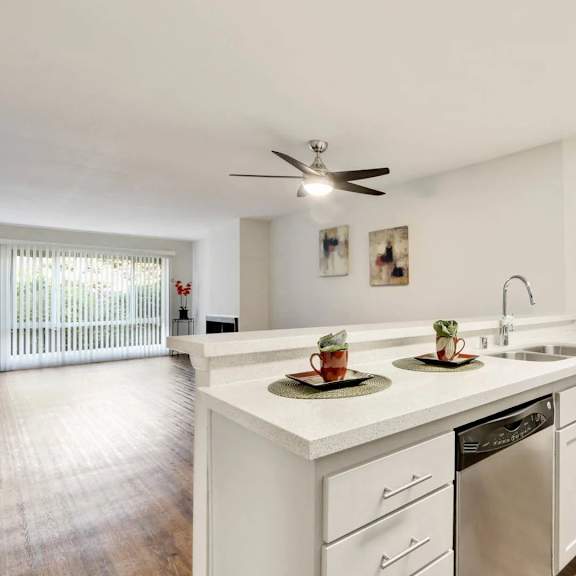 a white kitchen with a fan on the ceiling.