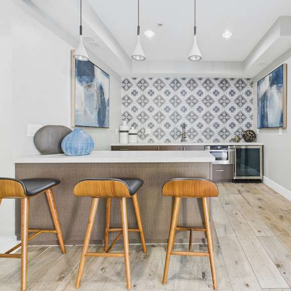 a kitchen with a bar area and a wall hanging.