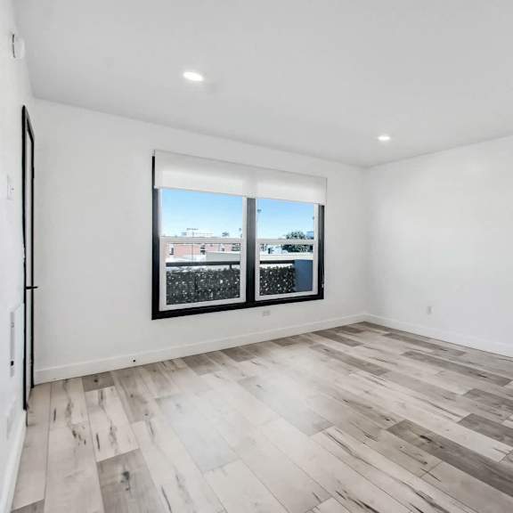 a room with a window and a wooden floor.