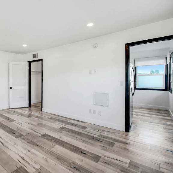 a room with a white wall and a wooden floor.