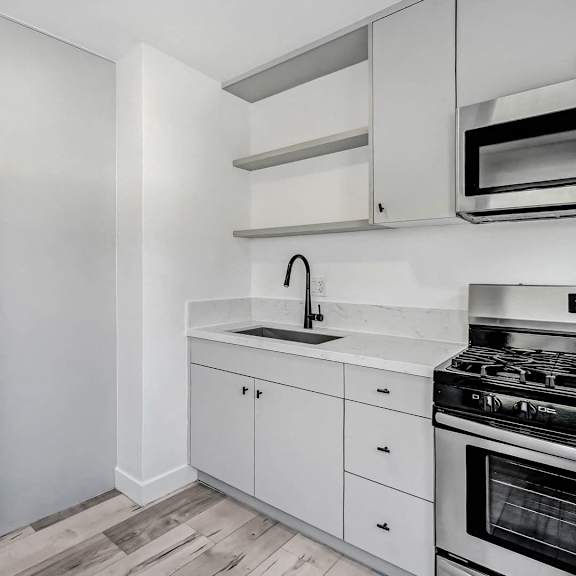 a modern kitchen with white cabinets and a stainless steel refrigerator.
