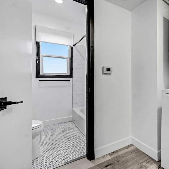 a white washing machine is in a small laundry room.