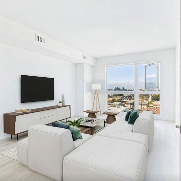 a living room with a white couch and a television.