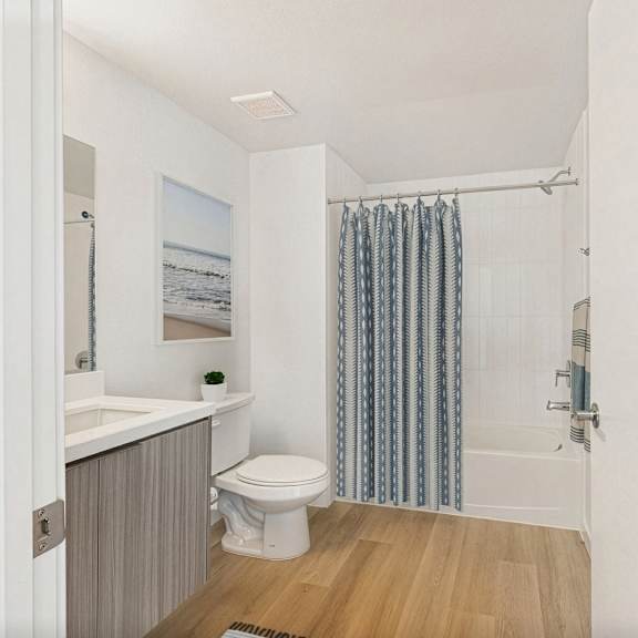a bathroom with a toilet, sink, and shower curtain.