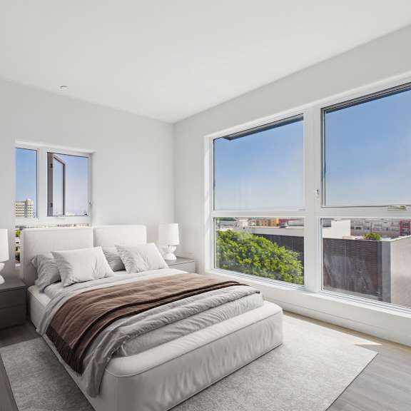 a bedroom with a large bed and a view of the city.