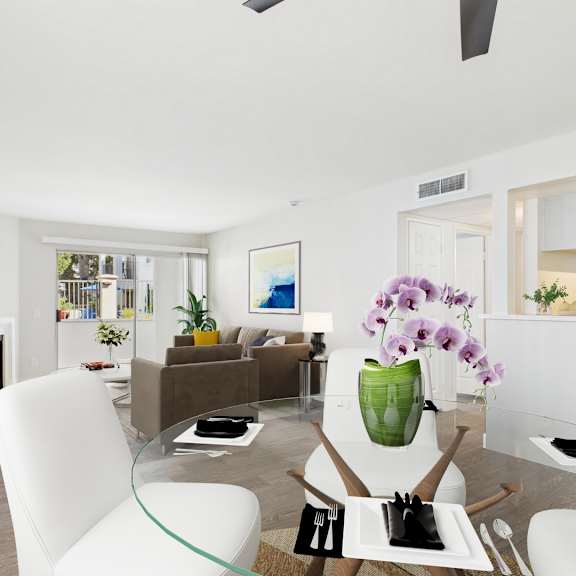 a modern living room with a glass table and white chairs.