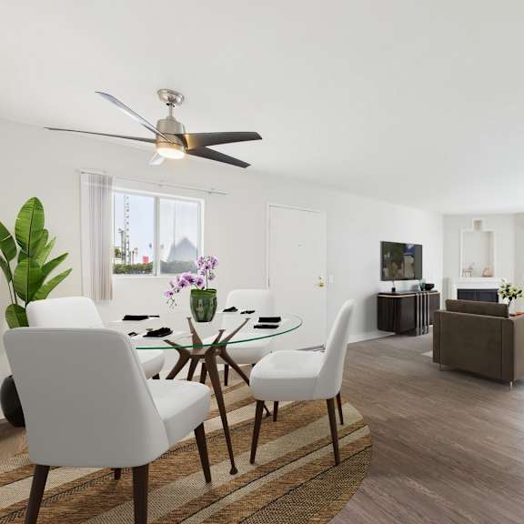 a modern living room with a glass dining table and white chairs.