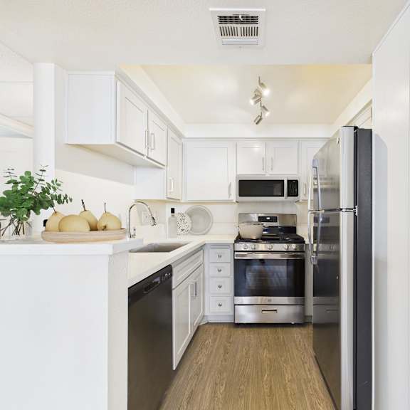 a modern kitchen with white cabinets and stainless steel appliances.