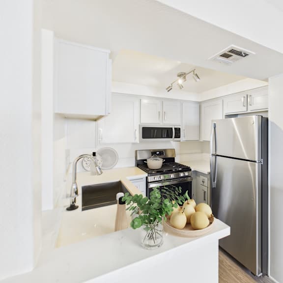 a kitchen with a refrigerator, stove, and sink.