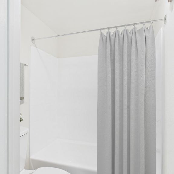 a white bathroom with a shower curtain.