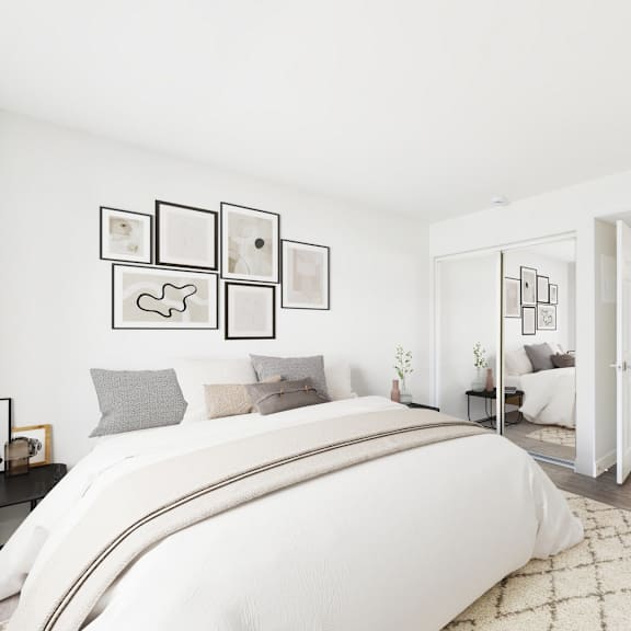 a white bedroom with a large bed and pictures on the wall.