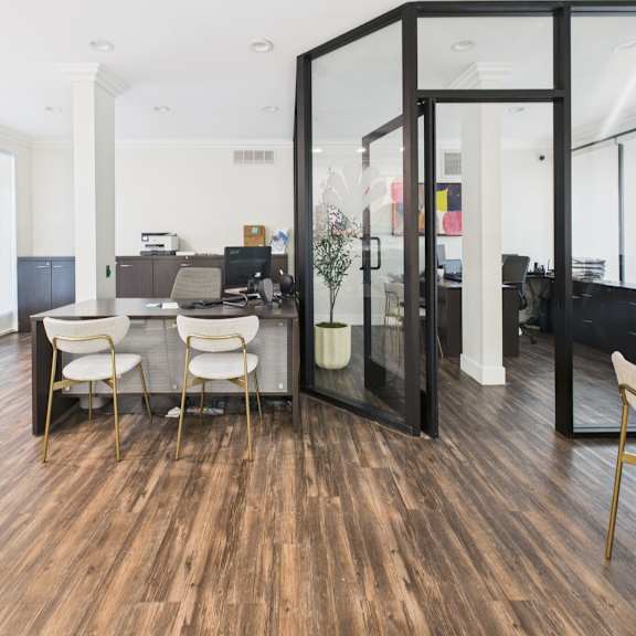 a room with a desk and chairs in it.