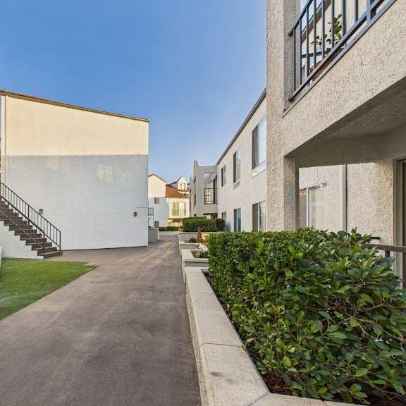 a long, narrow road separates two buildings.