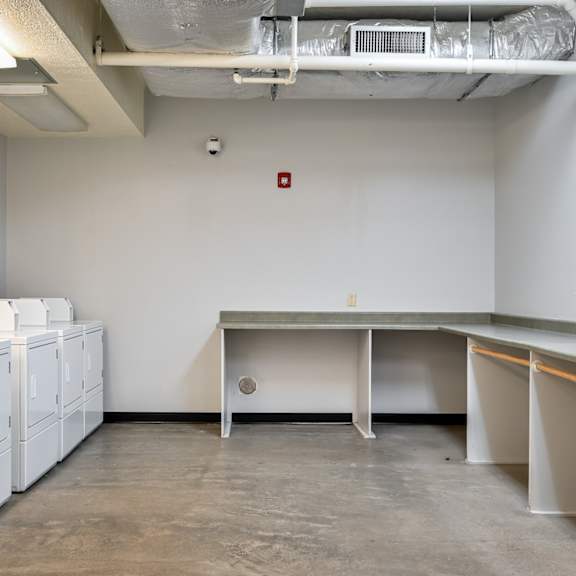 an empty room with washes and dryers in a building
