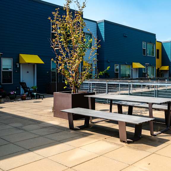 a communal seating area with benches and a tennis court