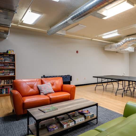 a game room with a ping pong table and couches