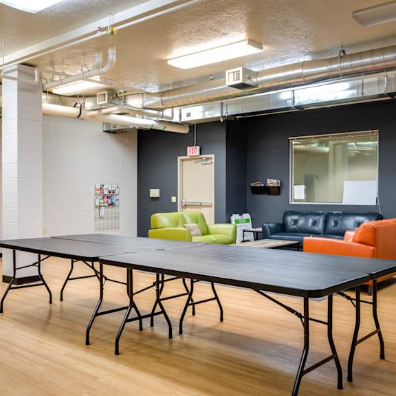 a room with a ping pong table and couches