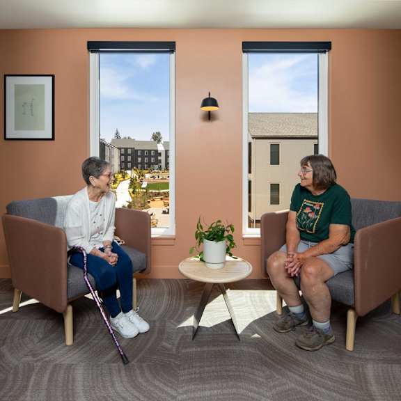 two people sitting in a room with orange walls.