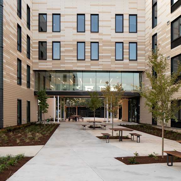 a modern building with a large glass entrance and wooden exterior.