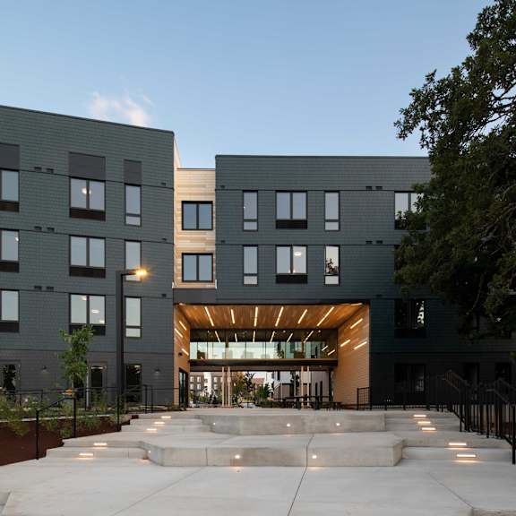 a modern building with a large entrance and steps leading up to it.