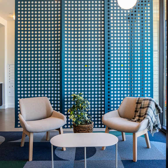 two chairs and a table are in front of a blue and white wall.