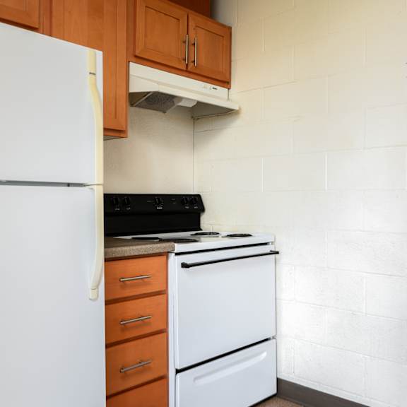 an empty kitchen with a white refrigerator and stove