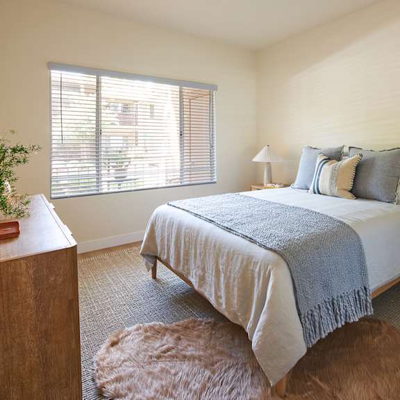 a bedroom with a bed, a nightstand, and a rug.
