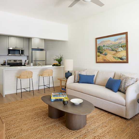 a living room with a couch, a coffee table, and a painting on the wall.