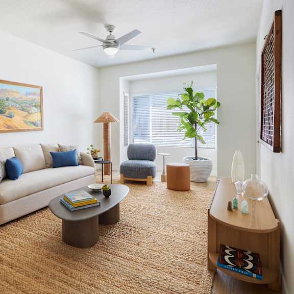 a living room with a couch, chair, and a painting on the wall.