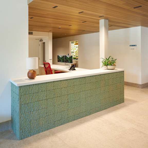 a reception desk with a green tile pattern.