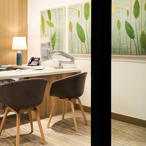 a modern office with a wooden desk and two chairs.